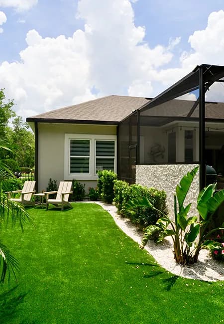 Side elevation of a home showing the stone knee wall and planted beds