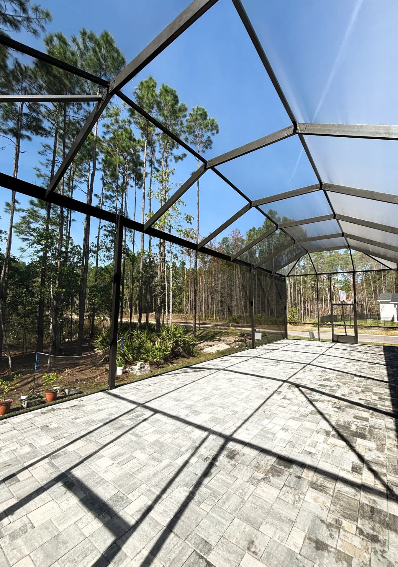 A newly laid paver patio inside a tall bronze enclosure