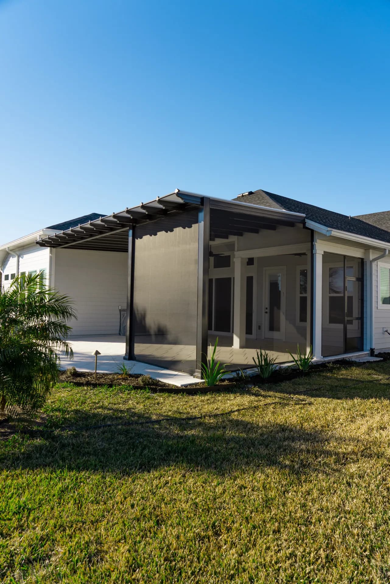 A screened lanai with a pergola-style front on a new-construction home